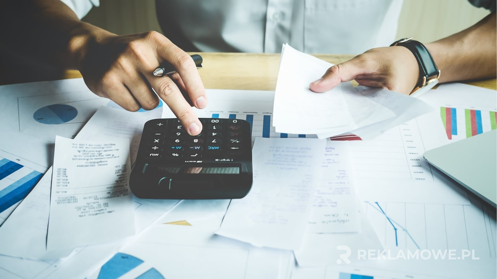 Kalkulator na biurku, symbolizujący analizę kosztów